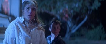 Movie still from “The Monster Squad” (1987), directed by Fred Dekker – A boy and a girl are standing next to each other; Close Up shot, Low angle