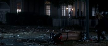 Movie still from “The Monster Squad” (1987), directed by Fred Dekker – A person sitting on a bench near a fire hydrant at night; Wide shot, High angle