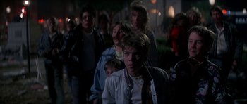Movie still from “The Monster Squad” (1987), directed by Fred Dekker – A group of people standing in the street at night; Medium shot, Over the shoulder angle