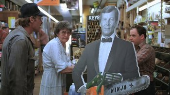 Movie still from “The Mosquito Coast” (1986), directed by Peter Weir – A cardboard cut out of a man in a tuxedo; Medium shot, Over the shoulder angle