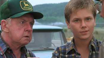 Movie still from “The Mosquito Coast” (1986), directed by Peter Weir – A man and a young boy standing next to each other in front of a car; Close Up shot, Low angle