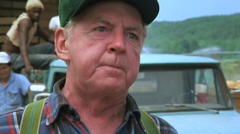 Movie still from “The Mosquito Coast” (1986), directed by Peter Weir – An older man wearing a green hat and plaid shirt; Close Up shot, Low angle