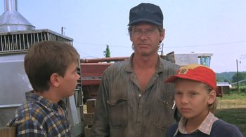 Movie still from “The Mosquito Coast” (1986), directed by Peter Weir – A man standing next to two young boys; Close Up shot, Low angle