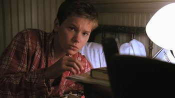 Movie still from “The Mosquito Coast” (1986), directed by Peter Weir – A young man looking at a laptop computer; Close Up shot, Low angle