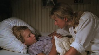 Movie still from “The Mosquito Coast” (1986), directed by Peter Weir – A young boy and his mother in a hospital bed; Medium shot, High angle