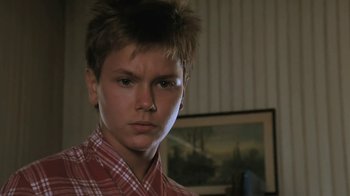 Movie still from “The Mosquito Coast” (1986), directed by Peter Weir – A young man in a red and white checkered shirt; Close Up shot, Low angle