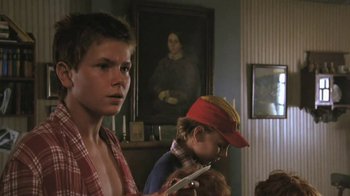 Movie still from “The Mosquito Coast” (1986), directed by Peter Weir – Two young boys in front of a portrait of a woman; Close Up shot, Low angle