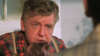 Movie still from “The Mosquito Coast” (1986), directed by Peter Weir – An older man in a plaid shirt is looking at the camera; Close Up shot, Over the shoulder angle