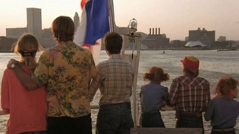 Movie still from “The Mosquito Coast” (1986), directed by Peter Weir – A group of people standing on a boat in the water; Wide shot, Over the shoulder angle