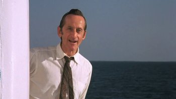 Movie still from “The Mosquito Coast” (1986), directed by Peter Weir – An older man wearing a white dress shirt and a tie; Close Up shot, Low angle