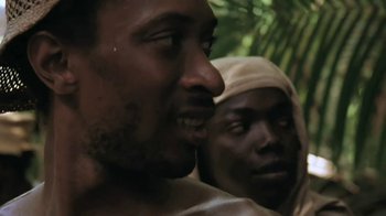 Movie still from “The Mosquito Coast” (1986), directed by Peter Weir – A man with no shirt is looking at the camera while another man with no shirt is looking at the camera; Close Up shot, Over the shoulder angle