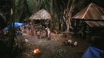 Movie still from “The Mosquito Coast” (1986), directed by Peter Weir – A group of people standing around in a forest; Extreme Wide shot, High angle
