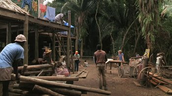 Movie still from “The Mosquito Coast” (1986), directed by Peter Weir – A group of people standing on top of a wooden structure; Wide shot, High angle