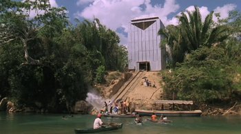 Movie still from “The Mosquito Coast” (1986), directed by Peter Weir – A group of people in a boat on a body of water; Extreme Wide shot, High angle