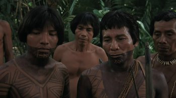 Movie still from “The Mosquito Coast” (1986), directed by Peter Weir – A group of men standing next to each other in the woods; Close Up shot, High angle