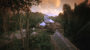 Movie still from “The Mosquito Coast” (1986), directed by Peter Weir – An aerial view of a village in the middle of the jungle; Extreme Wide shot, High angle