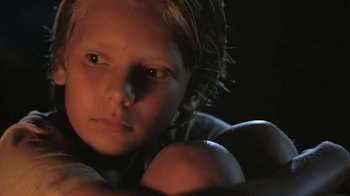 Movie still from “The Mosquito Coast” (1986), directed by Peter Weir – A young boy is looking into the camera; Close Up shot, Low angle