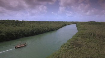 Movie still from “The Mosquito Coast” (1986), directed by Peter Weir – An aerial view of a boat in the water; Extreme Wide shot, High angle