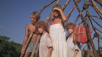 Movie still from “The Mosquito Coast” (1986), directed by Peter Weir – A group of people standing next to each other in front of a sky background; Medium shot, Low angle