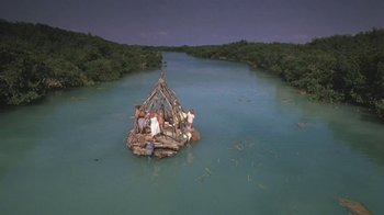 Movie still from “The Mosquito Coast” (1986), directed by Peter Weir – A group of people on a raft in the middle of a river; Extreme Wide shot, High angle