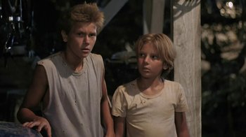 Movie still from “The Mosquito Coast” (1986), directed by Peter Weir – Two young people standing next to each other; Close Up shot, Low angle