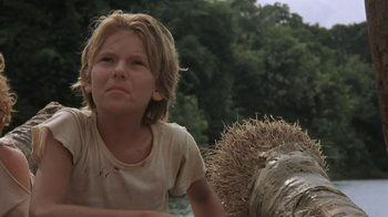 Movie still from “The Mosquito Coast” (1986), directed by Peter Weir – A young boy sitting on top of a hay bale; Close Up shot, Low angle