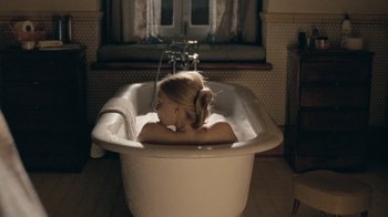 Movie still from “The Moth Diaries” (2011), directed by Mary Harron – A young girl sitting in a bath tub in a bathroom; Wide shot, High angle