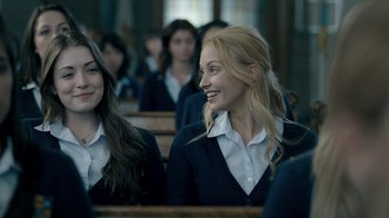 Movie still from “The Moth Diaries” (2011), directed by Mary Harron – Two women sitting next to each other in a classroom; Close Up shot, Over the shoulder angle