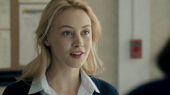 Movie still from “The Moth Diaries” (2011), directed by Mary Harron – A woman with blonde hair and blue eyes looking at the camera; Close Up shot, Over the shoulder angle
