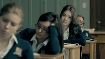 Movie still from “The Moth Diaries” (2011), directed by Mary Harron – A woman sitting at a desk in front of another person; Close Up shot, Over the shoulder angle