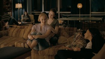 Movie still from “The Moth Diaries” (2011), directed by Mary Harron – Two young women sitting on a couch in a living room; Medium shot, Over the shoulder angle