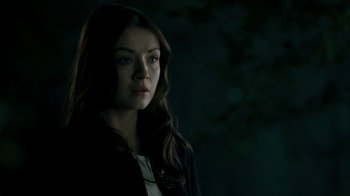 Movie still from “The Moth Diaries” (2011), directed by Mary Harron – A woman with long brown hair standing in the dark; Close Up shot, Over the shoulder angle