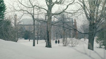 Movie still from “The Moth Diaries” (2011), directed by Mary Harron – Two people walking in the snow near a tree; Extreme Wide shot, High angle