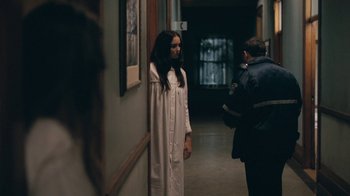 Movie still from “The Moth Diaries” (2011), directed by Mary Harron – A woman standing in a hallway next to a police officer; Medium shot, Over the shoulder angle