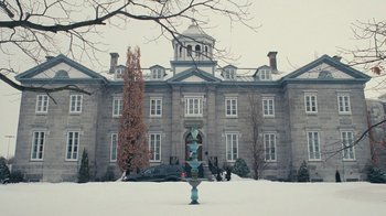 Movie still from “The Moth Diaries” (2011), directed by Mary Harron – A large building with a statue in front of it; Extreme Wide shot, Low angle