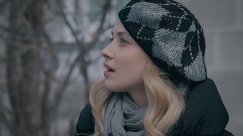 Movie still from “The Moth Diaries” (2011), directed by Mary Harron – A woman wearing a black and white hat and a scarf; Close Up shot, Over the shoulder angle