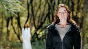 Movie still from “The Moth Diaries” (2011), directed by Mary Harron – A woman standing in front of another woman in a forest; Medium shot, Over the shoulder angle