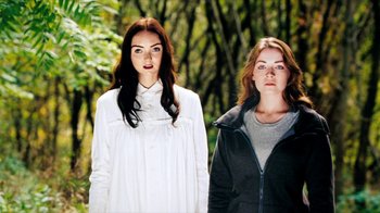 Movie still from “The Moth Diaries” (2011), directed by Mary Harron – Two women standing next to each other in the woods; Medium shot, Low angle