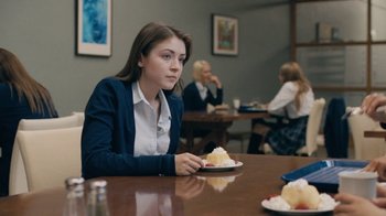 Movie still from “The Moth Diaries” (2011), directed by Mary Harron – A woman sitting at a table with a plate of cake; Medium shot, Over the shoulder angle