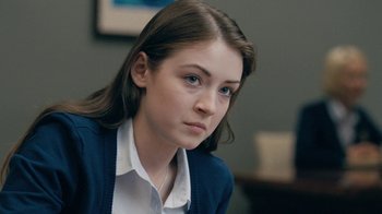Movie still from “The Moth Diaries” (2011), directed by Mary Harron – A young girl is sitting in front of a wall; Close Up shot, Over the shoulder angle