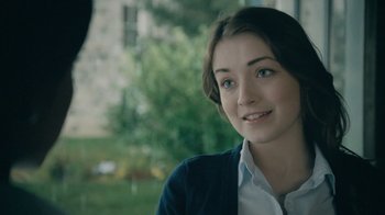 Movie still from “The Moth Diaries” (2011), directed by Mary Harron – A young woman is smiling for the camera outside; Close Up shot, Over the shoulder angle
