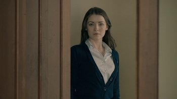 Movie still from “The Moth Diaries” (2011), directed by Mary Harron – A woman standing in front of a door wearing a blue jacket; Close Up shot, Over the shoulder angle