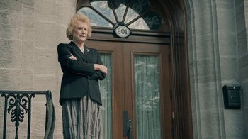 Movie still from “The Moth Diaries” (2011), directed by Mary Harron – An older woman standing in front of a door way; Medium shot, Low angle