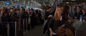 Movie still from “The Mountain Between Us” (2017), directed by Hany Abu-Assad – A woman walking through an airport with luggage; Medium shot, Over the shoulder angle