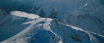 Movie still from “The Mountain Between Us” (2017), directed by Hany Abu-Assad – A person is standing on a snowy mountain top; Extreme Wide shot, Low angle