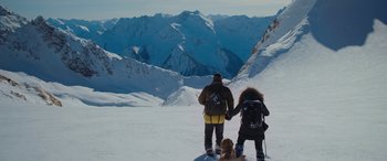 Movie still from “The Mountain Between Us” (2017), directed by Hany Abu-Assad – A couple of people standing on top of a snow covered slope; Wide shot, High angle