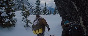 Movie still from “The Mountain Between Us” (2017), directed by Hany Abu-Assad – A man with a backpack walking through the snow; Wide shot, High angle