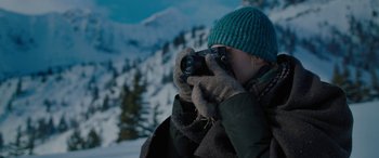 Movie still from “The Mountain Between Us” (2017), directed by Hany Abu-Assad – A woman taking a picture of a snowy mountain; Close Up shot, Over the shoulder angle