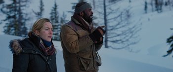 Movie still from “The Mountain Between Us” (2017), directed by Hany Abu-Assad – A man and a woman are standing in the snow; Medium shot, Low angle