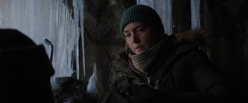 Movie still from “The Mountain Between Us” (2017), directed by Hany Abu-Assad – A woman wearing a green hat and a black jacket; Close Up shot, Over the shoulder angle